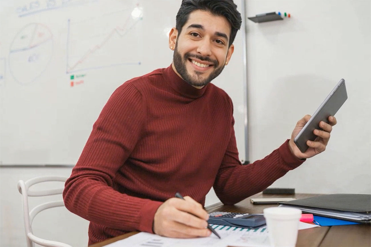 male working at desk with pen and paper