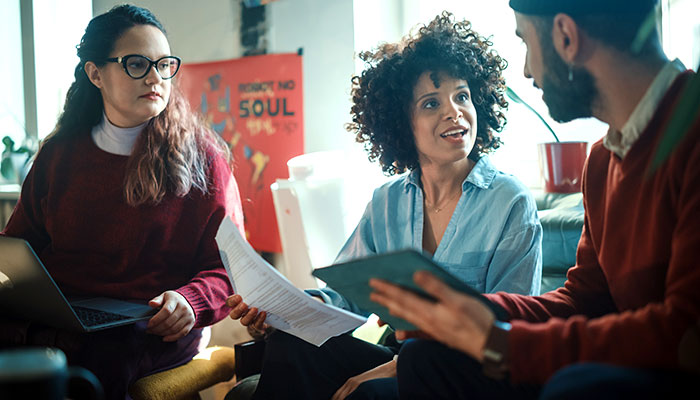 a female community worker in conversation with a man and woman