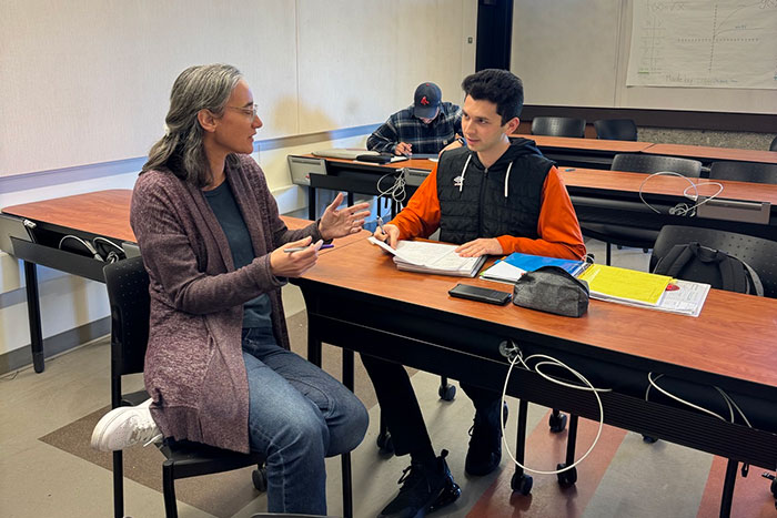 instructor talking with a student at table