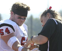 Student wrapping athlete's arm