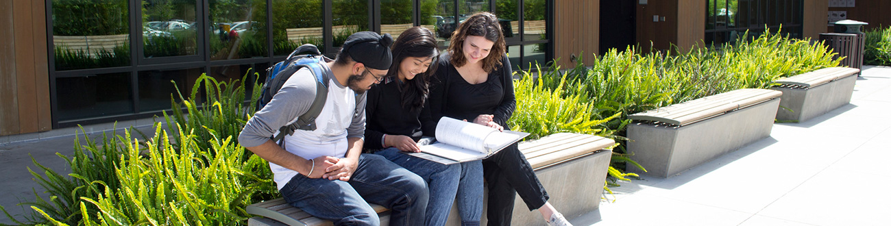 three students sitting on bench