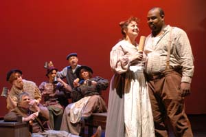 Mrs. Lovett (Diana Torres Koss) and Sweeney Todd (James Monroe Iglehart) conspire as fellow Londoners look on.